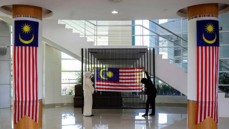 Staff of Universiti Malaysia Pahang Al-Sultan Abdullah (UMPSA) join forces to put up the Jalur Gemilang in celebration of National Month, as captured during a photoBERNAMA survey at the UMPSA campus here today. – BERNAMA