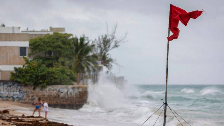 A ripped red flag warning of rip current waves as Category 5 Hurricane Erin approaches in San Juan, Puerto Rico, on August 16, 2025. Hurricane Erin on Saturday strengthened to a “catastrophic” Category 5 storm as it barrelled towards the Caribbean, with weather officials warning of possible flash floods and landslides. (Photo by Ricardo ARDUENGO / AFP)