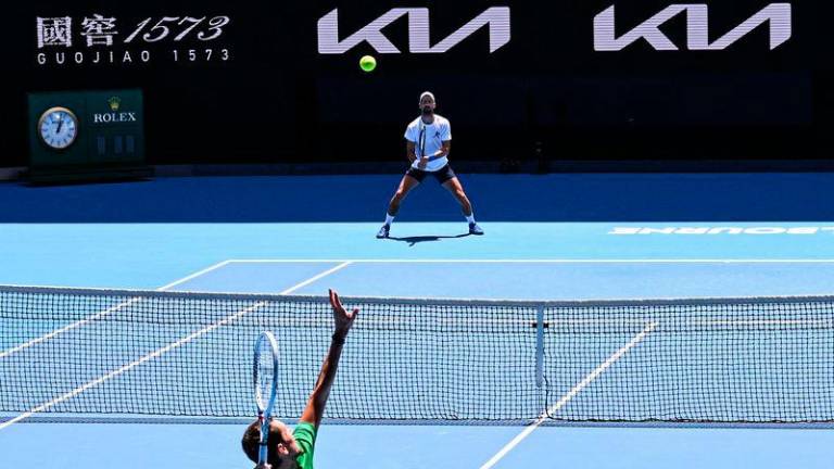 Serbia's Novak Djokovic (top) looks on as Russia's Daniil Medvedev serves during a practice session ahead of the Australian Open tennis tournament in Melbourne on January 11, 2025. - AFPPIX