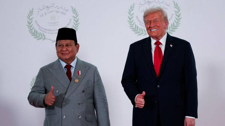 U.S. President Donald Trump and Indonesia's President Prabowo Subianto gesture as they pose for a photo, at a world leaders' summit on ending the Gaza war, amid a U.S.-brokered prisoner-hostage swap and ceasefire deal between Israel and Hamas, in Sharm el-Sheikh, Egypt, October 13, 2025. - REUTERSPIX/Suzanne Plunkett/Pool