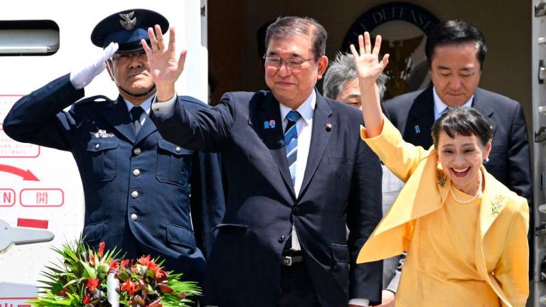 Japan’s Prime Minister Shigeru Ishiba (2nd L) and his wife Yoshiko Ishiba (R) wave as they disembark the plane upon their arrival at the Ninoy Aquino International Airport in Manila on April 29, 2025. (Photo by TED ALJIBE / AFP)