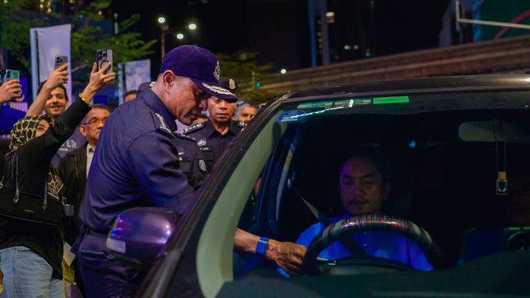 Kuala Lumpur Police Chief Datuk Fadil Marsus (left) issues a warning notice during the Law Compliance Operation (Op PUU) in Bukit Bintang on September 13, 2025. – BERNAMA