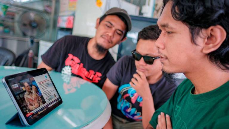 Golongan belia, Muhammad Ridhwan Abdul Fattah, 21, (kanan) bersama rakannya menyaksikan secara dalam talian pembentangan Rancangan Malaysia Ke-13 (RMK-13) oleh Perdana Menteri Datuk Seri Anwar Ibrahim, di Pekan Nanas, di sini, hari ini - BERNAMA