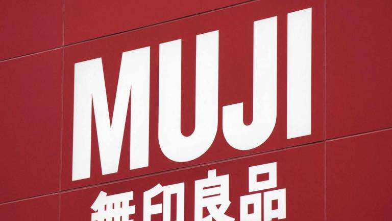 The logo of Japan’s popular lifestyle company Muji (Mujirushi Ryohin) is displayed at a shop in the Ginza shopping district of Tokyo on October 20, 2025. (Photo by Kazuhiro NOGI / AFP)