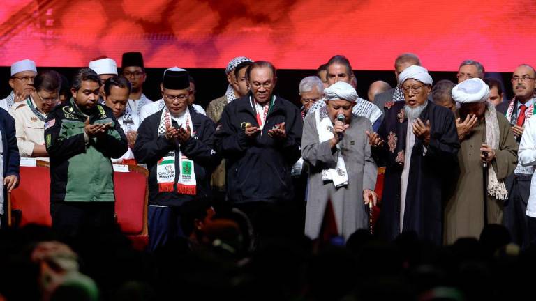 Perdana Menteri Datuk Seri Anwar Ibrahim mengaminkan doa ketika bacaan Qunut Nazilah semasa Himpunan Solidariti Bersama Gaza di Stadium Axiata Arena, Bukit Jalil semalam- BERNAMA