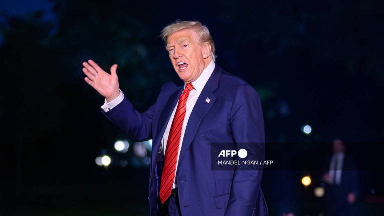 US President Donald Trump waves as he walks across the South Lawn upon return to the White House in Washington, DC on August 3, 2025 after spending the weekend at his Bedminster residence. - AFP
