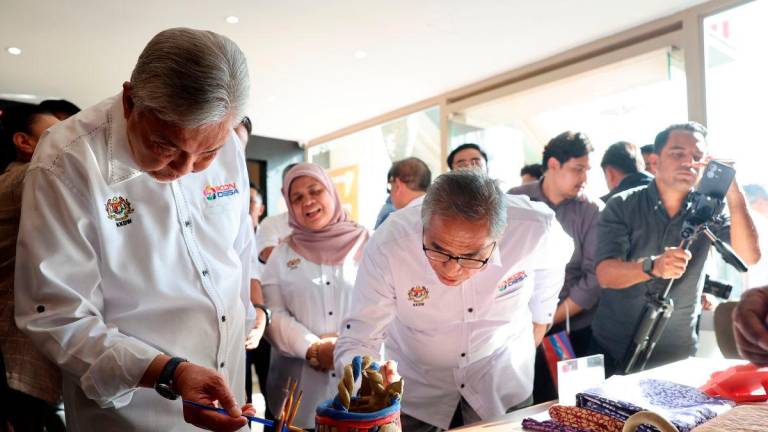 Timbalan Perdana Menteri merangkap Menteri Kemajuan Desa dan Wilayah (KKDW), Datuk Seri Dr Ahmad Zahid Hamidi (kiri) mewarnakan labu sayong pada Majlis Pelancaran IkonDesa@Putrajaya di Souq Putrajaya, Presint 1, hari ini. Turut kelihatan Ketua Setiausaha Negara, Tan Sri Shamsul Azri Abu Bakar (tiga kiri) dan Timbalan Menteri (KKDW), Datuk Rubiah Wang (tengah)- BERNAMA