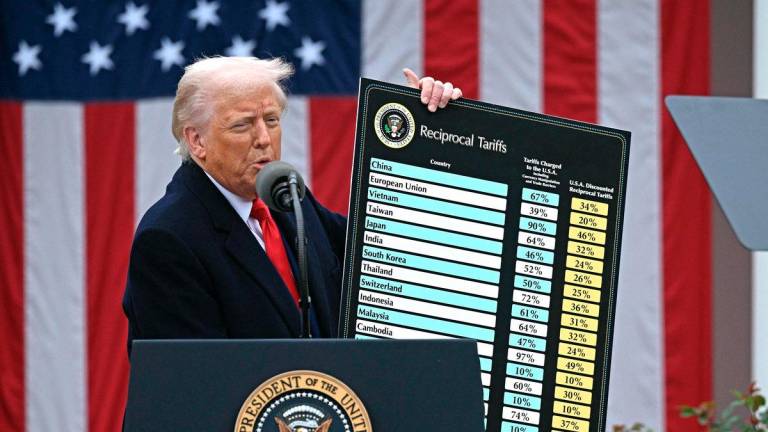 US President Donald Trump delivers remarks on reciprocal tariffs as US Secretary of Commerce Howard Lutnick holds a chart during an event in the Rose Garden entitled “Make America Wealthy Again” at the White House in Washington, DC, on April 2, 2025. - AFP