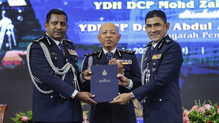 Pengarah Pengurusan Bukit Aman Datuk Abdul Aziz Abdul Majid (tengah) menyaksikan penyerahan tugas antara Datuk Hussein Omar Khan (kiri) kepada DCP Mohd Zaini Abu Hassan (kanan) selaku Pemangku Ketua Polis Selangor pada Majlis Serah Terima Tugas Jawatan Ketua Polis Selangor di Dewan D'Cerana, Ibu Pejabat Polis Kontinjen Selangor hari ini. - BERNAMA