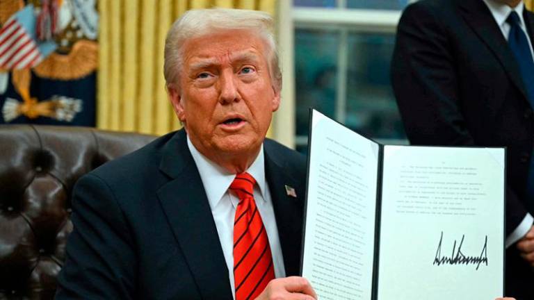 US President Donald Trump signs an executive order in the Oval Office of the White House on February 10, 2025, in Washington, DC. (Photo by ANDREW CABALLERO-REYNOLDS / AFPpix)