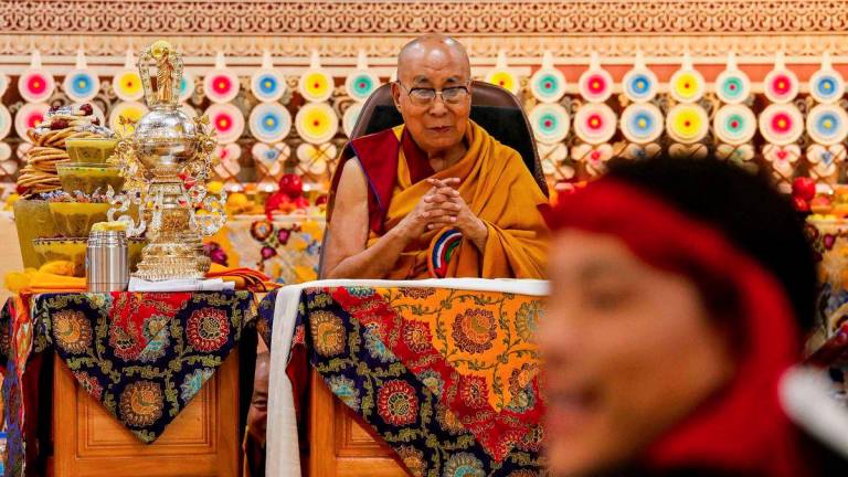 Tibetan spiritual leader the Dalai Lama looks on as offerings presented by Buddhist followers are laid on a table during a Long Life Prayer offering ceremony at the Main Tibetan Temple in McLeod Ganj, near Dharamsala on June 30, 2025. - AFPPIX