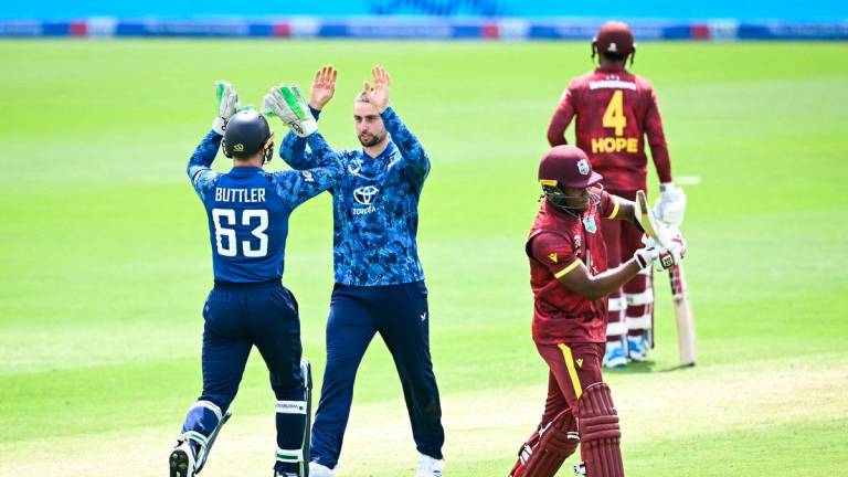 England’s Will Jacks (C) celebrates with England’s Jos Buttler (L) taking the wicket of West Indies’ Keacy Carty (front R) during the second One Day International (ODI) cricket match between England and West Indies at Sophia Gardens cricket ground in Cardiff on June 1, 2025. (Photo by Paul ELLIS / AFP)
