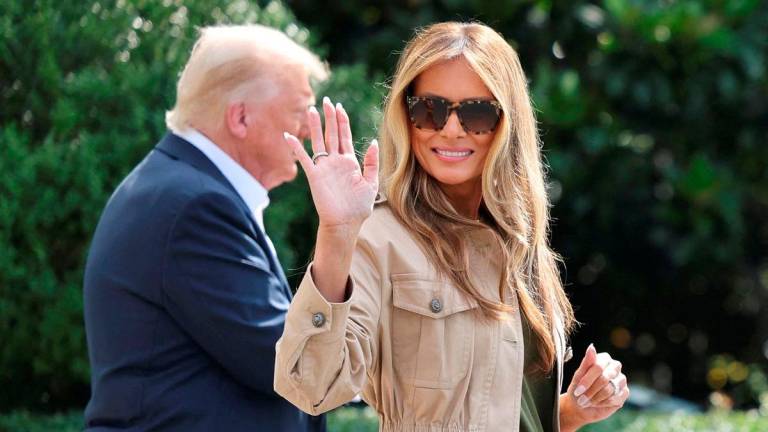 FILE PHOTO: First lady Melania Trump waves as she walks with U.S. President Donald Trump before they depart for travel to Texas to tour areas affected by deadly flash flooding, from the South Lawn of the White House in Washington, D.C., U.S., July 11, 2025. REUTERS/Jonathan Ernst/File Photo