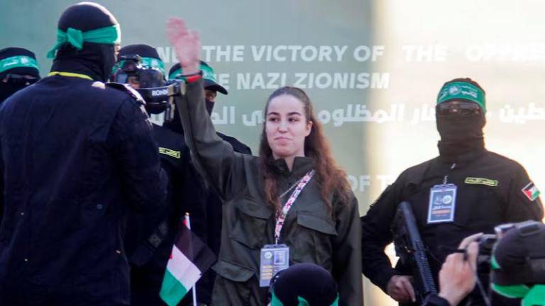 Female Israeli soldier Agam Berger gestures as she is released by Palestinian Hamas militants, as part of a ceasefire and a hostages-prisoners swap deal between Hamas and Israel, in Jabalia, in the northern Gaza Strip - REUTERSpix