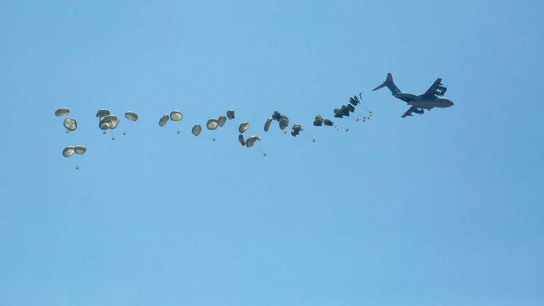 A picture taken from Northern Gaza's Jabalia shows an airplane conducting an airdrop of aid above the Israel-besieged Palestinian territory on August 1, 2025. - AFPPIX