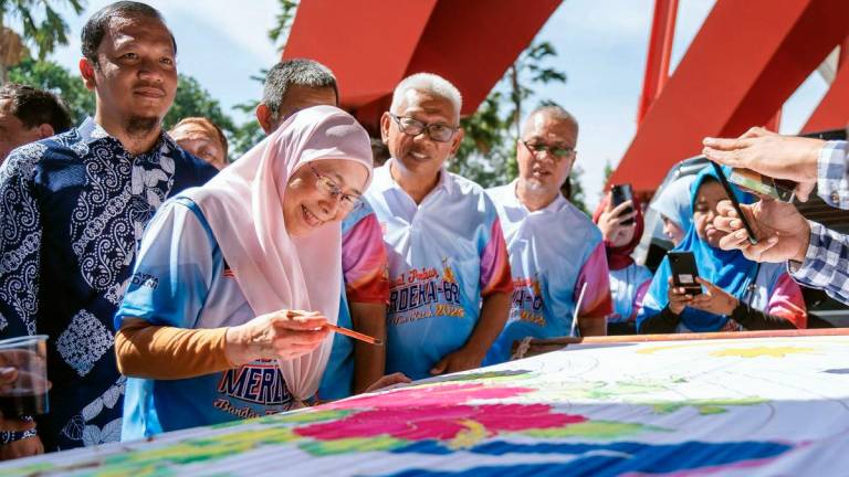 The Prime Minister’s wife and Member of Parliament for Bandar Tun Razak, Datuk Seri Dr Wan Azizah Wan Ismail (second from left), tried her hand at the batik canting activity while visiting the booths at the Opening Ceremony of the Ambang Merdeka Carnival for Bandar Tun Razak Parliament 2025 at the Kuala Lumpur Football Stadium grounds today. - BERNAMA