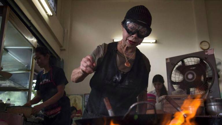 Jay Fai puts seafood in a frying pan whilst cooking in her restaurant, a day after her street-side eatery was recognised with a one-star Michelin guide, in Bangkok on December 7, 2017. - AFPPIX