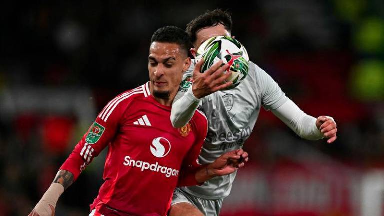 Barnsley's Irish defender #07 Corey O'Keeffe vies with Manchester United's Brazilian midfielder #21 Antony before hand-balling the ball in the lead up to Manchester United's fifth goal, during the English League Cup third round football match between Manchester United and Barnsley at Old Trafford in Manchester, north west England, on September 17, 2024. - AFPPIX