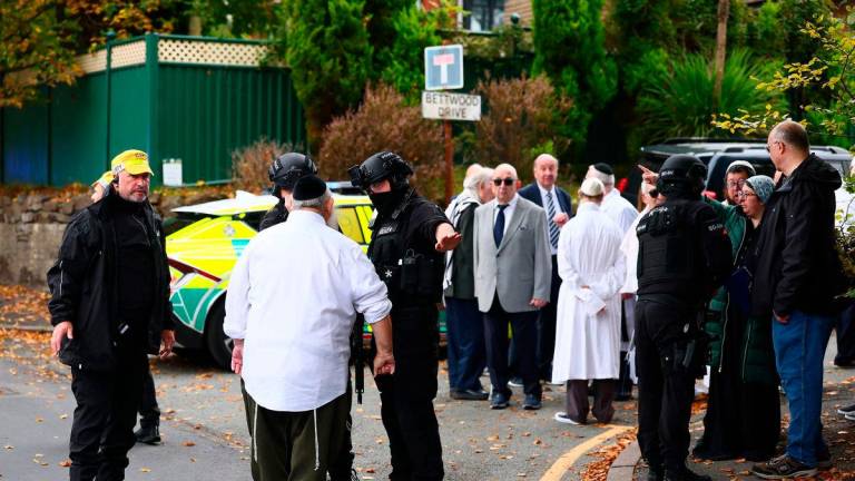Armed police officers talk with members of the community near Heaton Park Hebrew Congregation synagogue in Crumpsall, north Manchester, on October 2, 2025, following an incident at the synagogue. (Photo by Paul Currie / AFP)