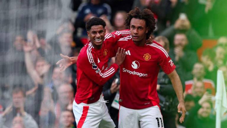 Manchester United's Dutch striker #11 Joshua Zirkzee (R) celebrates with Manchester United's English striker #10 Marcus Rashford (L) after scoring their second goal during the English Premier League football match between Manchester United and Everton at Old Trafford in Manchester, north west England, on December 1, 2024. - AFPPIX