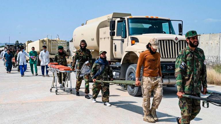 Afghan medical and Taliban security personnel carry stretchers for evacuated earthquake victims upon their arrival for medical assistance in Jalalabad on September 1, 2025. (Photo by Wakil KOHSAR / AFP)