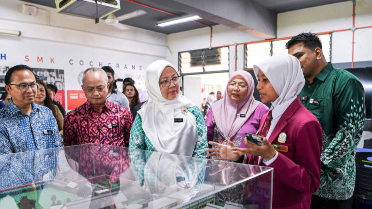 Minister in the Prime Minister’s Department (Federal Territories), Datuk Seri Dr Zaliha Mustafa (third from left), listening to an explanation by SMK Cochrane Resource Centre prefect, Nur Arisyah Abdul Rahman (right), during a brief visit after officiating the Federal Territories-level Leadership, Climate Change and Green Energy Programme (IKLIM) 2025 at SMK Cochrane, Kuala Lumpur, today. – BERNAMA
