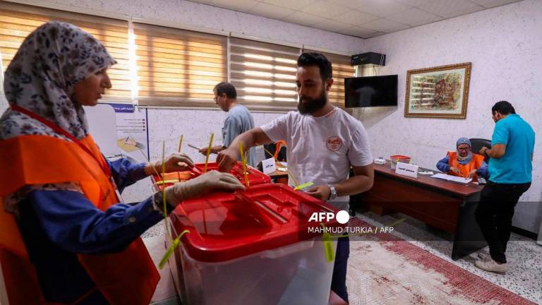 Libyan voters cast their ballots for municipal elections at a polling station in Tripoli on August 16, 2025. - Mahmud Turkia / AFP