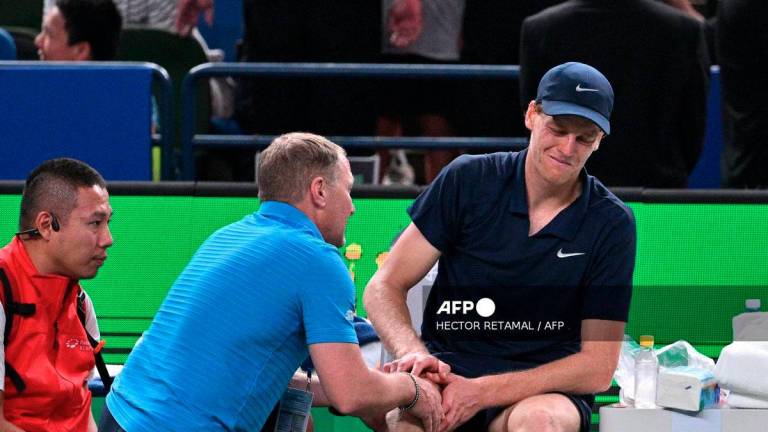 Italy's Jannik Sinner (R) reacts on the bench as he receives medical attention during his men's singles match against Netherlands' Tallon Griekspoor at the Shanghai Masters tennis tournament in Shanghai on October 6, 2025. - AFP