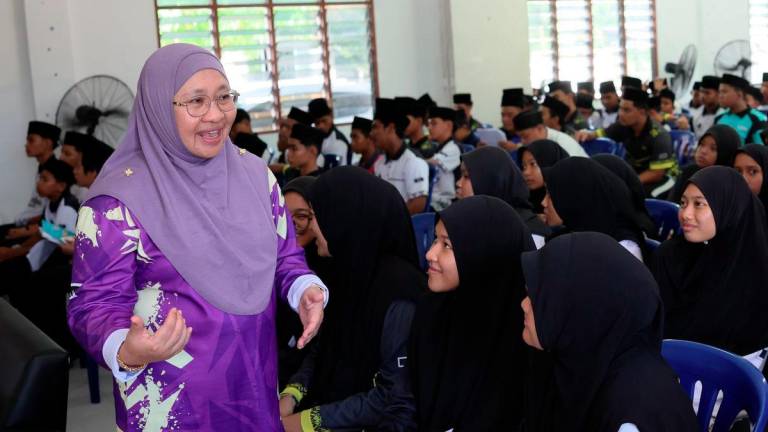 Pengarah Pertubuhan Keselamatan Sosial (Perkeso) Terengganu, Suhara Mustaffa (kiri) menyantuni anak-anak yatim yang menyertai sesi taklimat perkongsian hala tuju kerjaya pada Program Tanggungjawab Sosial Korporat (CSR) bersama Pertubuhan Kebajikan Anak-anak Yatim dan Miskin Darul Akhyar Terengganu di Batu Rakit, hari ini. - BERNAMA