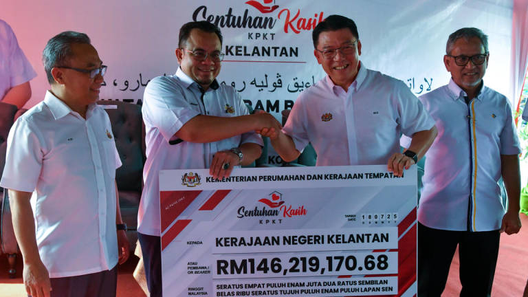 Menteri Perumahan dan Kerajaan Tempatan Nga Kor Ming (dua, kanan) menyampaikan replika cek kepada Exco Kerajaan Tempatan, Perumahan, Kesihatan dan Alam Sekitar Hilmi Abdullah (dua, kiri) pada Program Sentuhan Kasih Kementerian Perumahan dan Kerajaan Tempatan (KPKT) di Kampung Baru Cina hari ini. - BERNAMA