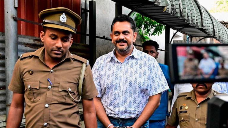 Police escort Sri Lanka’s former Agriculture Minister Shasheendra Rajapaksa (C) to a prison in Colombo on August 6, 2025. Sri Lanka’s anti-corruption authorities arrested a member of the once-powerful Rajapaksa family, a nephew of two presidents, Mahinda and Gotabaya on August 6, accusing him of illegally claiming reparations for property loss when his uncle was toppled as president three years ago. - Ishara S. KODIKARA / AFP