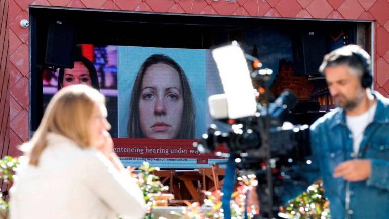 Members of the media work near a large screen showing a picture of convicted hospital nurse Lucy Letby, ahead of her sentencing, outside the Manchester Crown Court, in Manchester, Britain, August 21, 2023. REUTERS/Phil Noble/File Photo