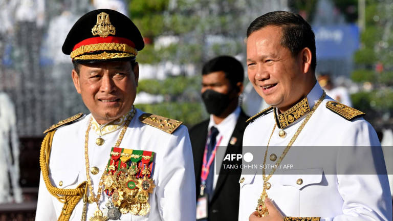Cambodia's Prime Minister Hun Manet (R) smiles as Commander-in-Chief of the Royal Cambodia Armed Forces Vong Pisen (L) looks on at the Independence Monument during a ceremony marking Cambodia's 71st Independence Day celebrations in Phnom Penh on November 9, 2024. - AFP