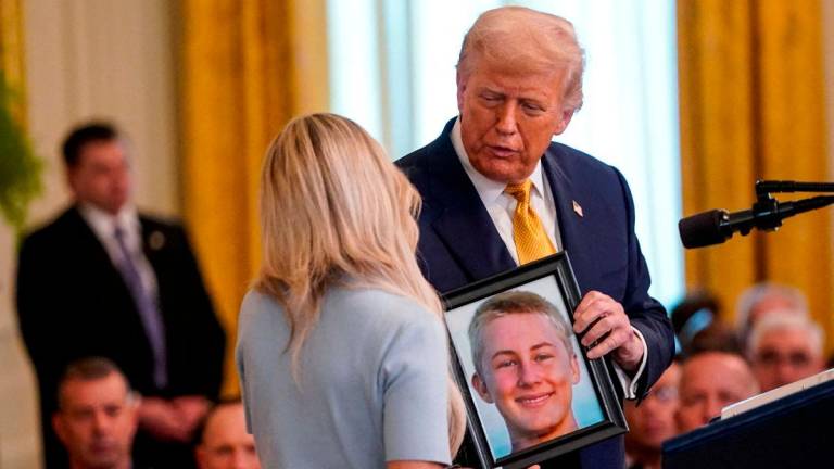 FILE PHOTO: U.S President Donald Trump holds a picture of Anne Fundner’s son, Weston, who died from fentanyl, before signing the HALT Fentanyl Act, in the East Room at the White House in Washington, D.C., U.S., July 16, 2025 - REUTERS