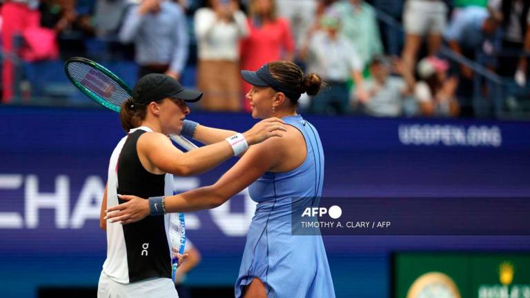USA's Amanda Anisimova (R) and Poland's Iga Swiatek hug after Anisimova won their women's singles quarterfinal tennis match on day eleven of the US Open tennis tournament at the USTA Billie Jean King National Tennis Center in New York City on September 3, 2025. - AFP
