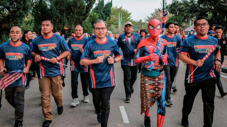 Menteri Komunikasi Datuk Fahmi Fadzil (tengah) turut menyertai program Merdeka 6.8KM Fun Run &amp; Walk sempena Majlis Peluncuran Bulan Kebangsaan dan Kibar Jalur Gemilang 2025 di Dataran Tanjung Emas di Muar hari ini - BERNAMA