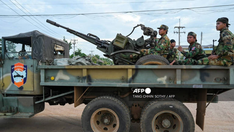 Cambodian soldiers stand on a military truck with an anti-aircraft gun in Oddar Meanchey province on July 25, 2025. - AFP