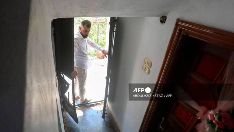 A man opens the door to a house, the site of a reported operation by the US-led coalition, in the town of Atme in northwestern Syria on August 20, 2025. (Photo by Abdulaziz KETAZ / AFP)