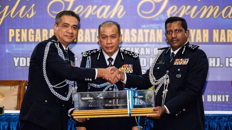Ketua Polis Negara Datuk Seri Mohd Khalid Ismail (tengah) menyaksikan penyerahan tongkat kuasa jawatan Pengarah Jabatan Siasatan Jenayah Narkotik (JSJN) Bukit Aman daripada Pemangku Pengarah JSJN Bukit Aman Datuk Mat Zani @ Mohd Salahuddin Che Ali (kiri) kepada Datuk Hussein Omar Khan (kanan) pada Majlis Serah Terima Tugas Pengarah JSJN di Mes Pegawai Kanan Polis di Bukit Aman, hari ini -BERNAMA