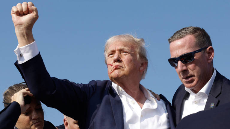 Republican presidential candidate former President Donald Trump pumps his fist as he is rushed offstage during a rally on July 13, 2024 in Butler, Pennsylvania. - Getty Images