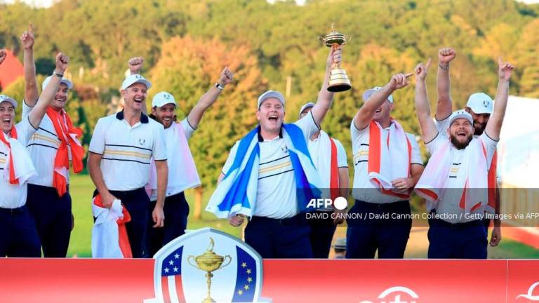 Robert MacIntyre of Europe holds the Ryder Cup trophy aloft as Team Europe celebrate their 15-13 victory during the trophy presentation ceremony following the Sunday singles matches of the 2025 Ryder Cup at Black Course at Bethpage State Park Golf Course on September 28, 2025 in Farmingdale, New York. - Getty Images via AFP