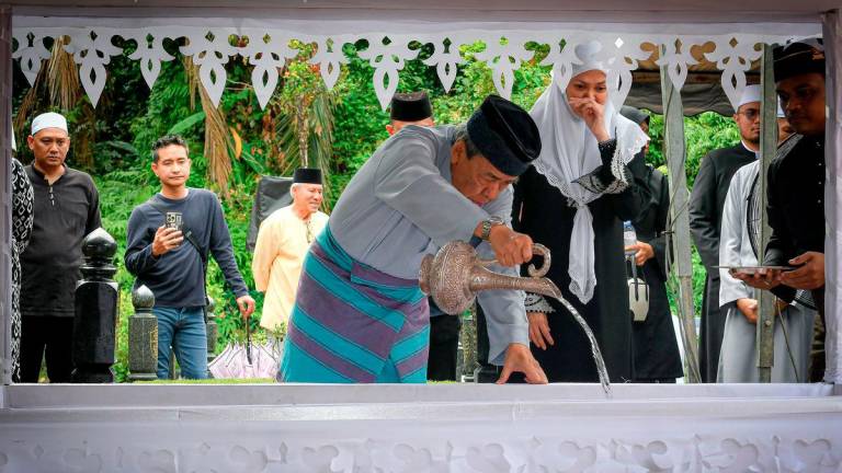 The Sultan of Selangor, Sultan Sharafuddin Idris Shah (centre), sprinkled rose water on the grave of his beloved mother-in-law, the late Esah Tahar, mother of the Tengku Permaisuri of Selangor, Tengku Permaisuri Norashikin (second from right), as a final tribute during the burial ceremony at the Royal Mausoleum in Shah Alam today. – BERNAMA