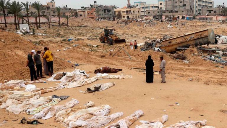 People gather near bodies lined up for identification after they were unearthed from a mass grave found in the Nasser Medical Complex in the southern Gaza Strip on April 25, 2024, amid the ongoing conflict between Israel and the Palestinian militant group Hamas/AFPPix