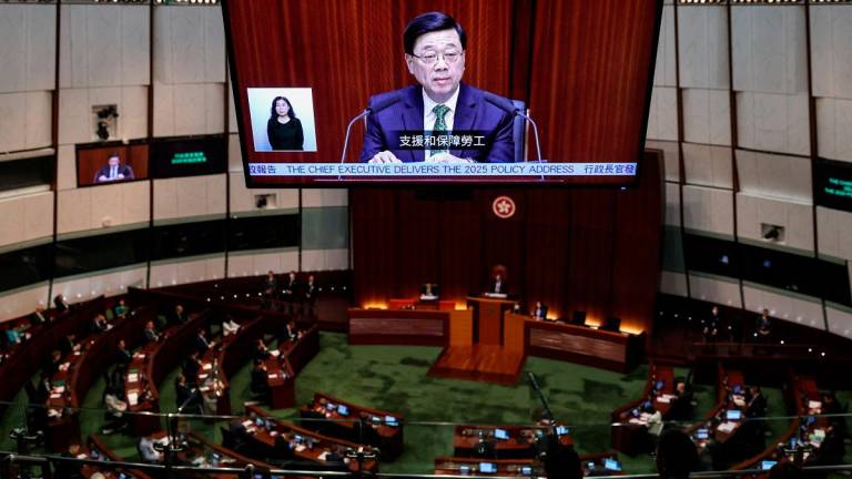A screen displays Hong Kong Chief Executive John Lee as he delivers his annual policy address at the Legislative Council in Hong Kong, China, September 17, 2025. - REUTERS/Tyrone Siu