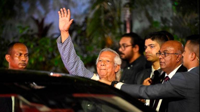 Nobel Peace Prize laureate Muhammad Yunus waves as he leaves his residence to attend the oath taking ceremony to lead an interim government, in Dhaka - REUTERSpix