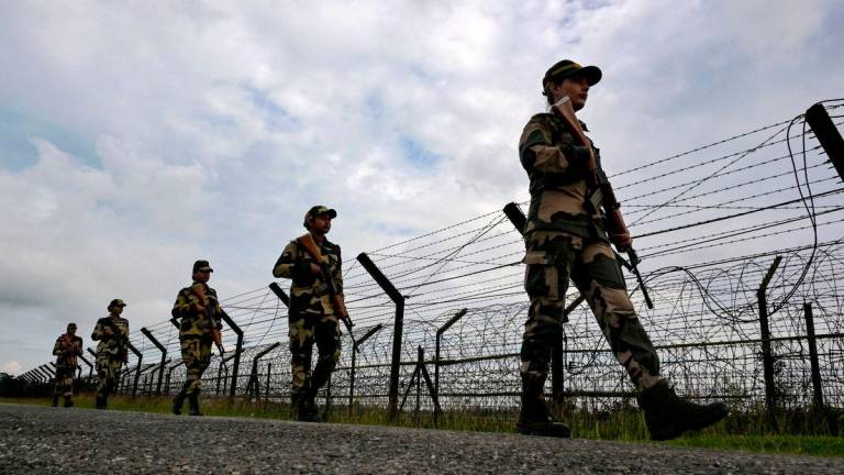 Border Security Force (BSF) women personnel patrol along the borderline fence at the India-Bangladesh border in Golakganj, Dhubri district in India’s Assam State on May 26, 2025. (Photo by Biju BORO / AFP)