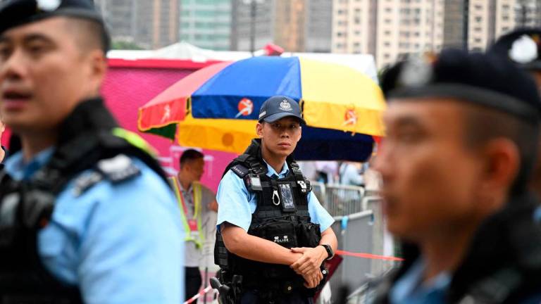 Police patrol outside a fair being held at Victoria Park in Hong Kong’s Causeway Bay district on June 4, 2025, where people traditionally gathered annually on June 4 to mourn the victims of China’s Tiananmen Square crackdown in 1989 - now banned following a national security law imposed on the city in 2020. (Photo by Peter PARKS / AFP)