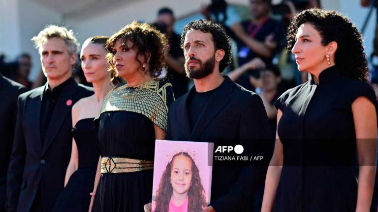 From left : US actor Joaquin Phoenix, US actress Rooney Mara, Tunisian director Kaouther Ben Hania, actor Motaz Malhees and actress Clara Khoury pose with a portrait of late Palestinian girl Hind Rajab during the red carpet for the movie The Voice of Hind Rajab presented in competition at the 82nd International Venice Film Festival, at Venice Lido on September 3, 2025. - AFP