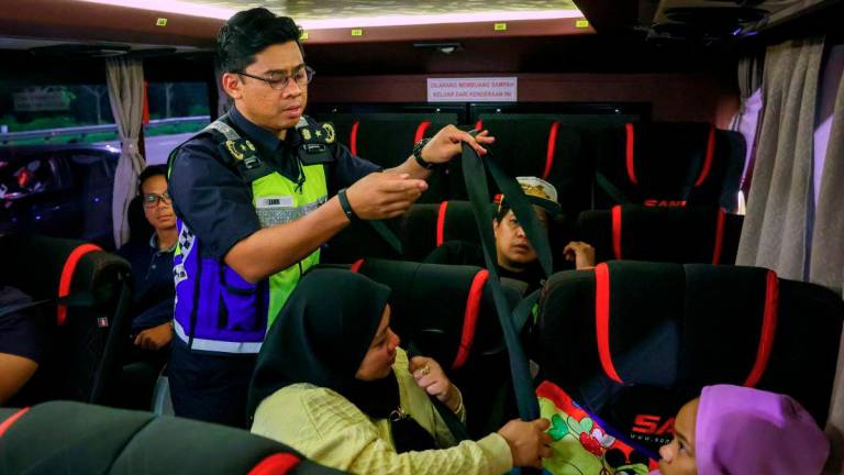 Director of the Terengganu Road Transport Department (JPJ), Mohd Zamri Samion, inspects the use of seat belts by bus passengers during the Special Operation Gempur on Commercial Vehicles at the Kuala Terengganu Toll Plaza last night. - BERNAMA