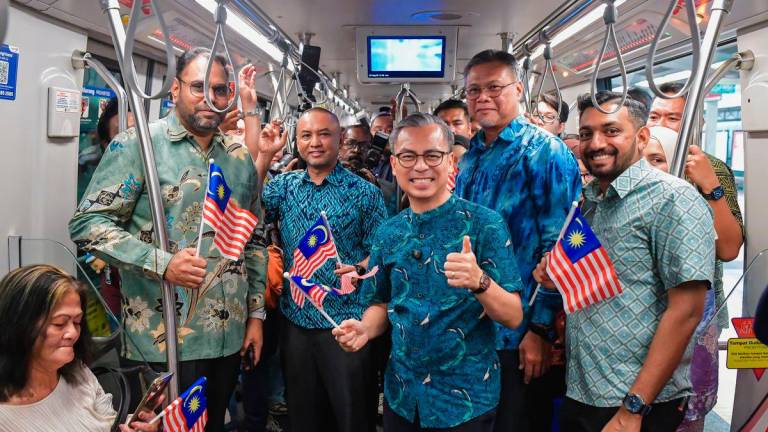 Menteri Komunikasi Datuk Fahmi Fadzil (tiga, kanan) bergambar sempena Program Edaran Jalur Gemilang Sempena Sambutan Hari Kebangsaan di Stesen LRT Bangsar hari ini. Turut hadir Ketua Pegawai Eksekutif Kumpulan Prasarana, Amir Hamdan (dua, kiri) -fotoBERNAMA